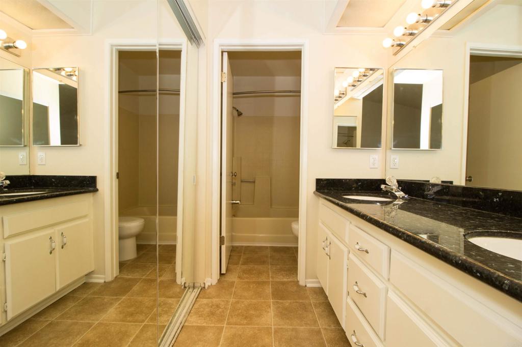 2023 Lakeridge Circle, Unit 203 Chula Vista, CA 91913 - Photo 19 of 24 a bathroom with a granite countertop sink and a mirror