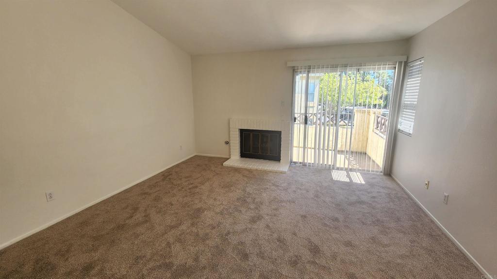 2023 Lakeridge Circle, Unit 203 Chula Vista, CA 91913 - Photo 5 of 24 an empty room with a fireplace and large window