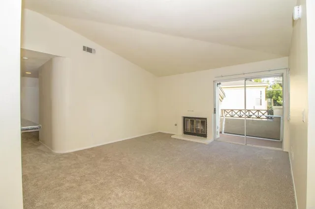 a view of a livingroom with an empty space and a fireplace