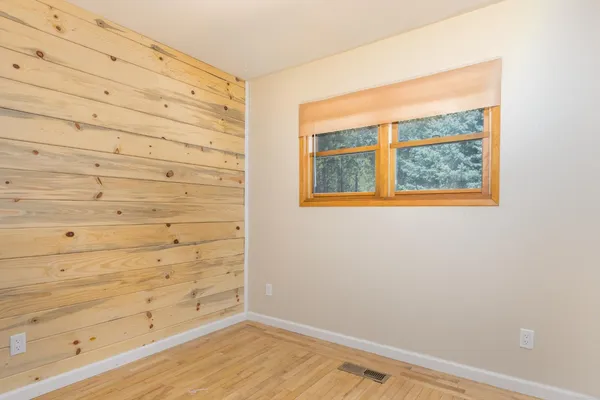 a view of empty room with wooden floor