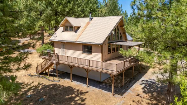 an aerial view of a house with a yard and tree s