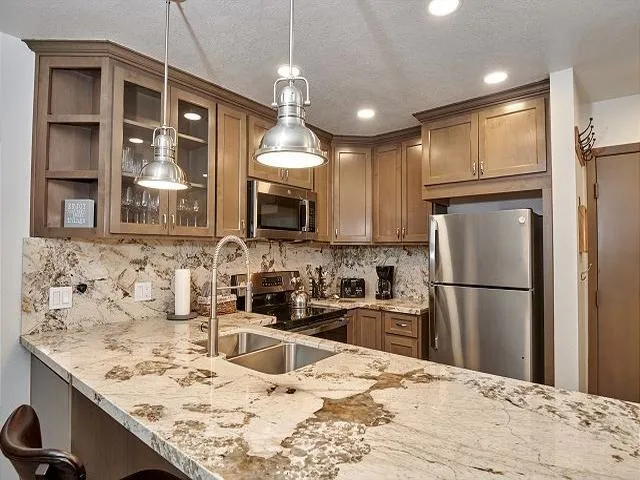 a kitchen with kitchen island a refrigerator stove microwave and cabinets