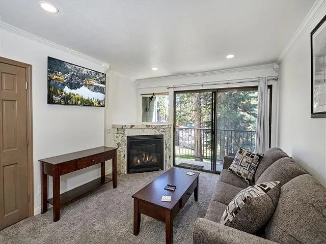 a living room with furniture and a view of kitchen