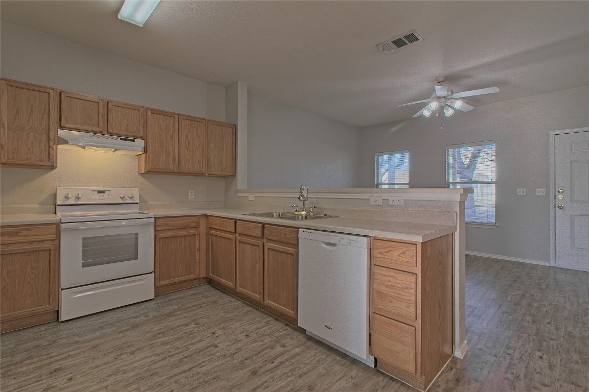 1102 East 3rd Street Georgetown, TX 78626 - Photo 12 of 36 Kitchen with white appliances, light countertops, and under cabinet range hood