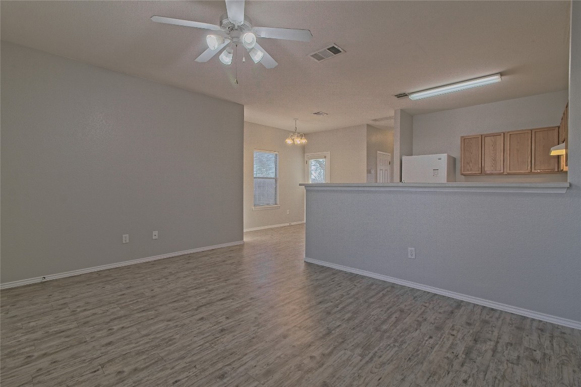 1102 East 3rd Street Georgetown, TX 78626 - Photo 8 of 36 Spare room featuring a chandelier, light wood finished floors, and a ceiling fan