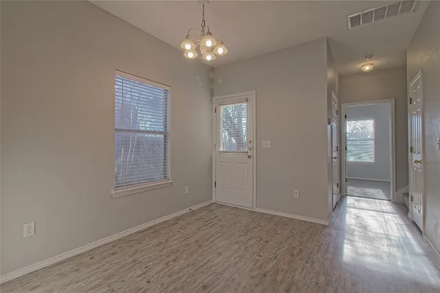 wooden floor in an empty room with a kitchen
