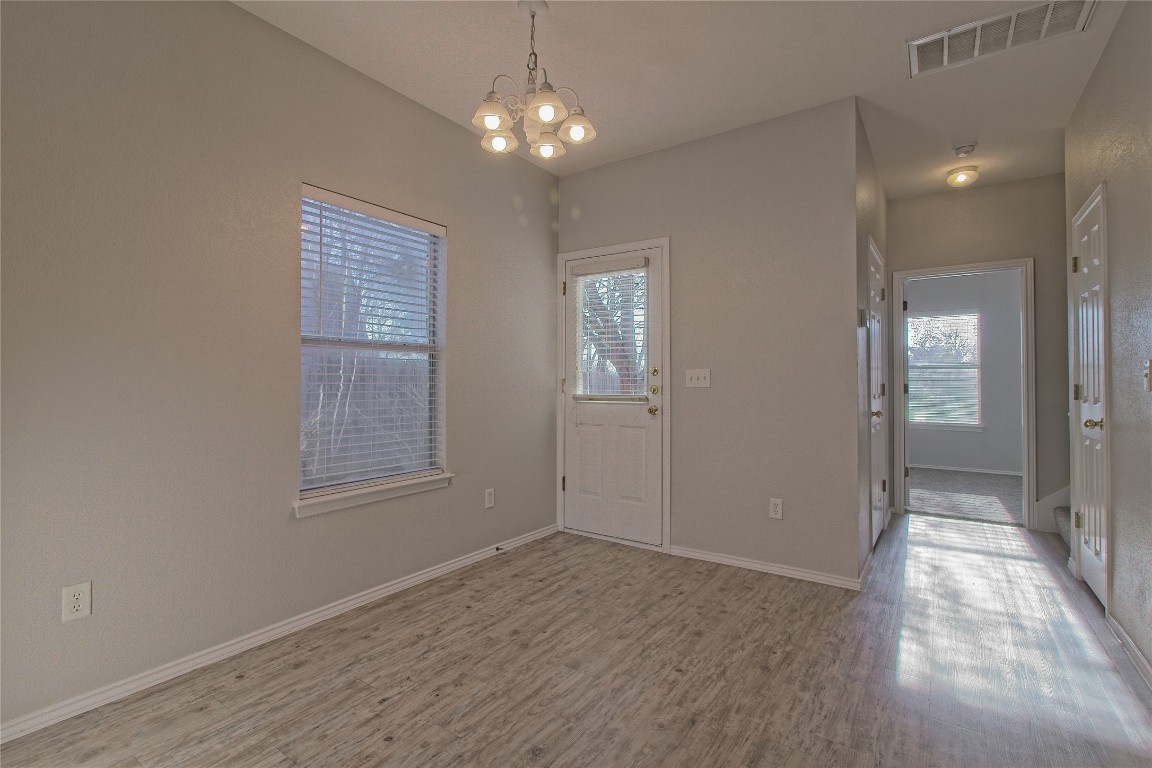 1102 East 3rd Street Georgetown, TX 78626 - Photo 9 of 36 Foyer with light wood-style flooring and a chandelier