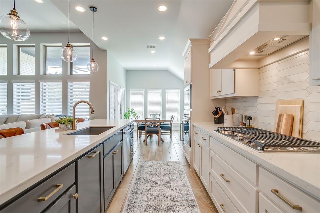 2453 Lazy Dog Lane Northlake, TX 76247 - Photo 12 of 40 Kitchen featuring decorative backsplash, light stone counters, white cabinets, recessed lighting, and hanging light fixtures