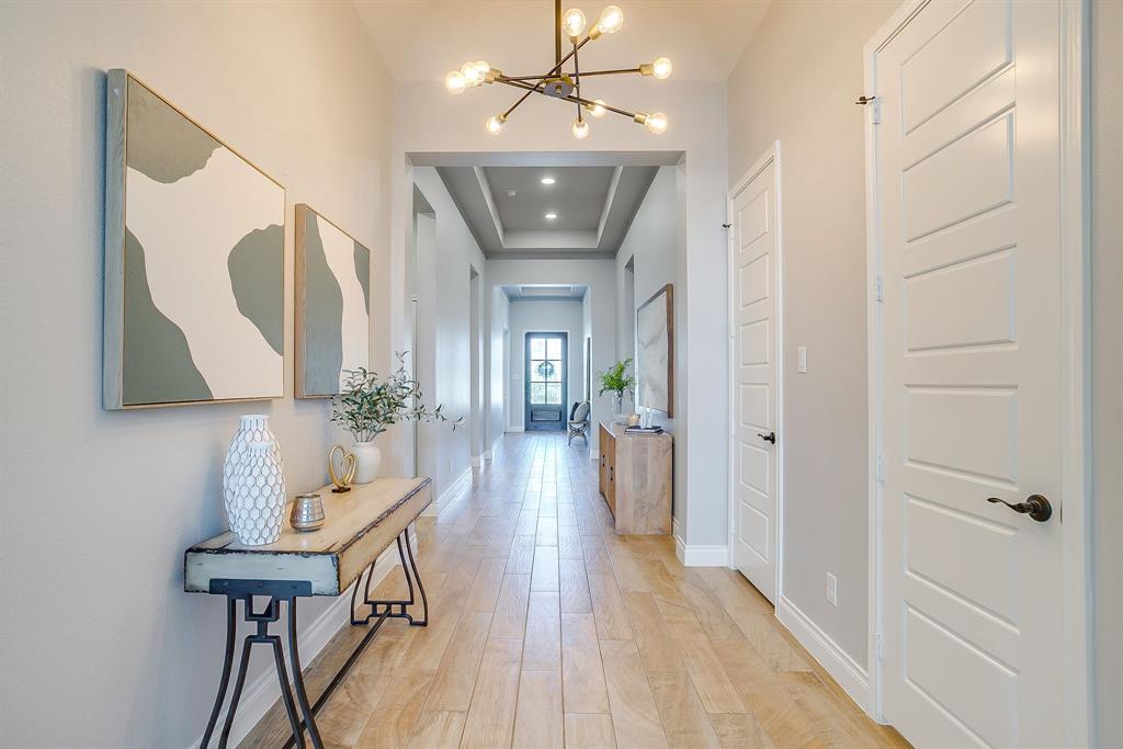 2453 Lazy Dog Lane Northlake, TX 76247 - Photo 6 of 40 Hallway featuring a chandelier, light wood-style floors, and a raised ceiling