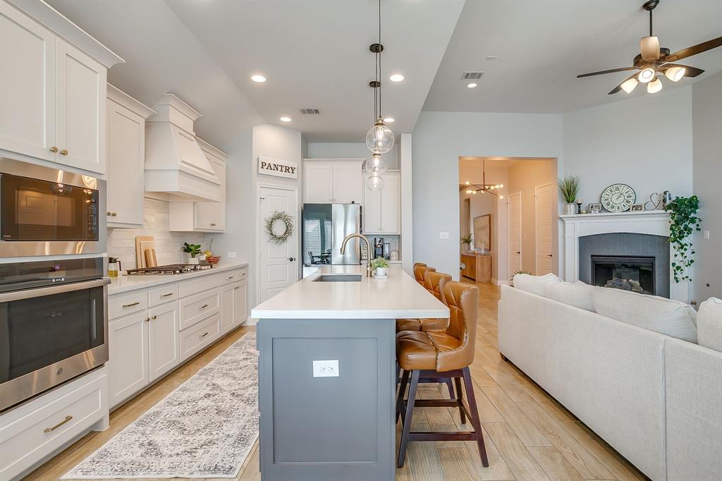 2453 Lazy Dog Lane Northlake, TX 76247 - Photo 10 of 40 Kitchen with a kitchen breakfast bar, recessed lighting, decorative backsplash, a center island with sink, and decorative light fixtures