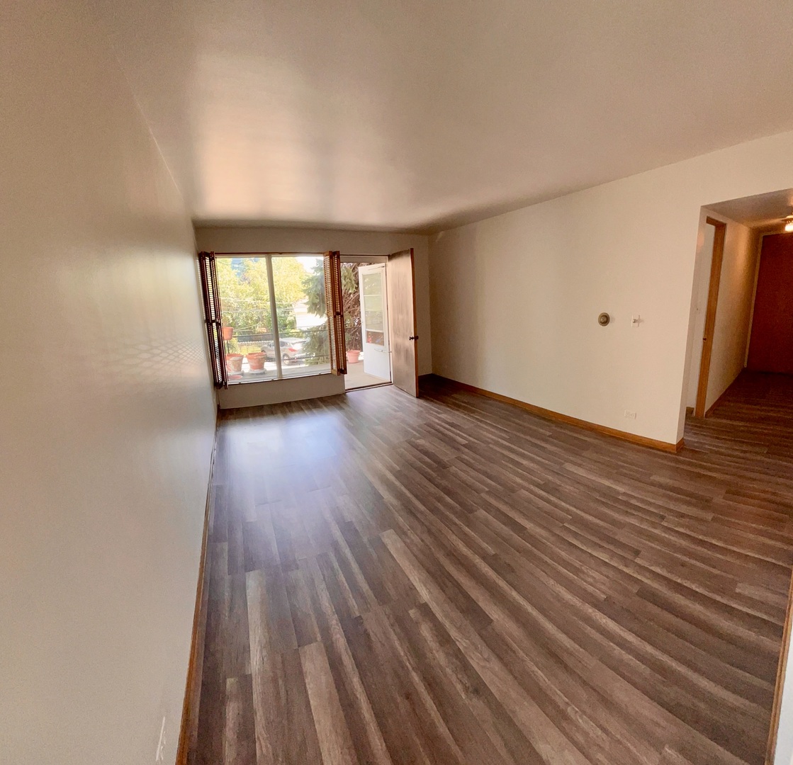 7446 Franklin Street, Unit 1NE Forest Park, IL 60130 - Photo 2 of 7 a view of an empty room with wooden floor and a window