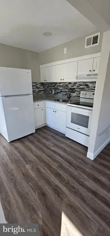 a kitchen with granite countertop a stove and a refrigerator