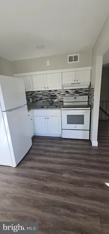 a kitchen with granite countertop a stove and cabinets