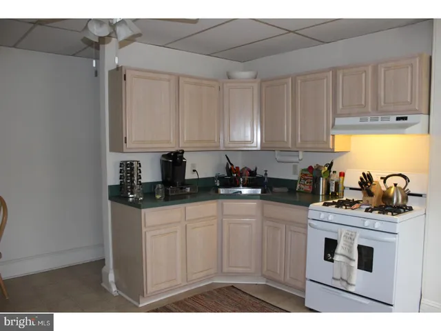 a kitchen with stainless steel appliances granite countertop a sink a stove and white cabinets