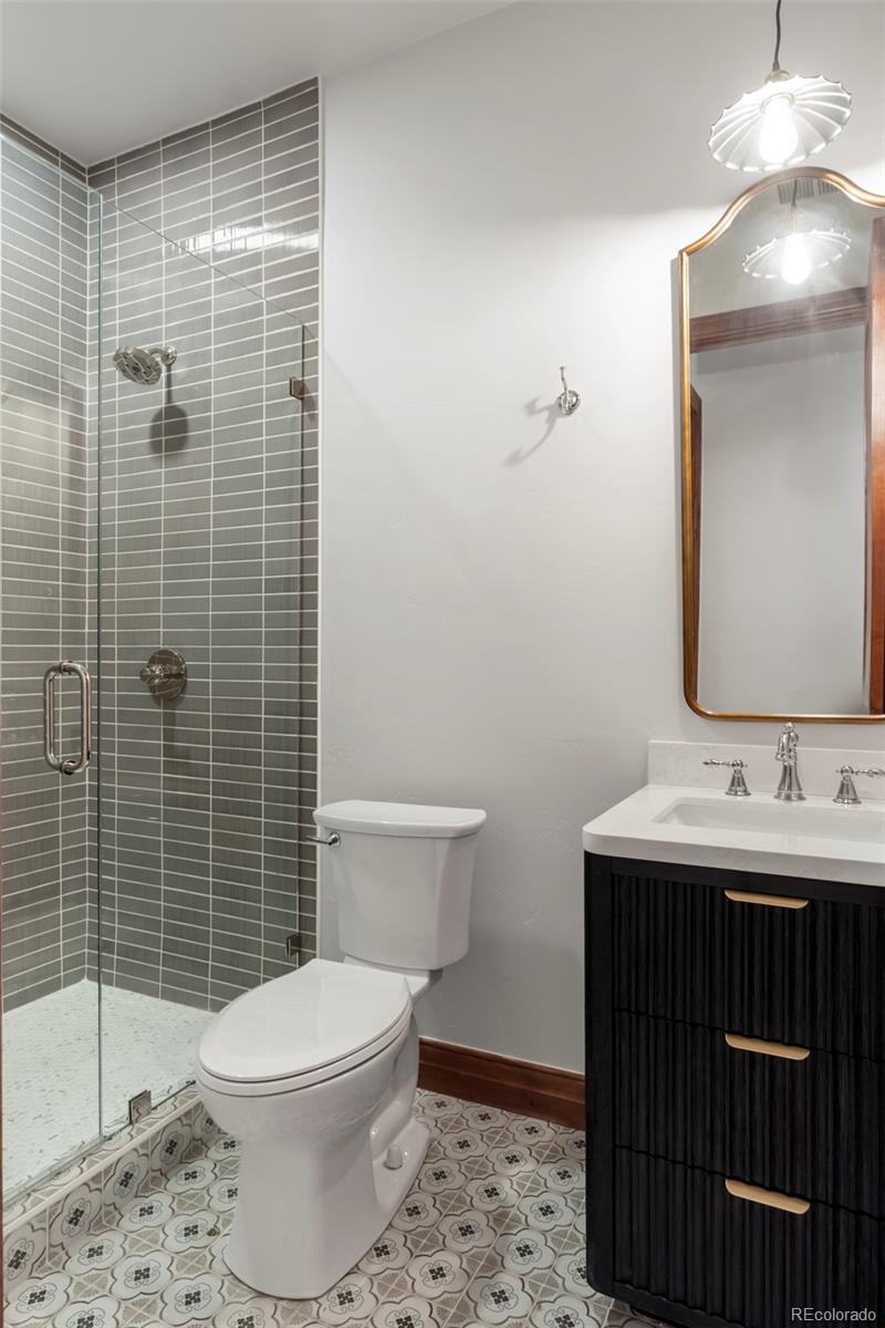 1026 South Cook Street Denver, CO 80209 - Photo 31 of 34 a bathroom with a toilet a sink and mirror