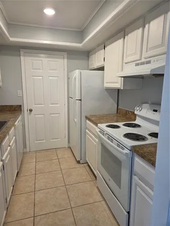 a kitchen with white cabinets and appliances