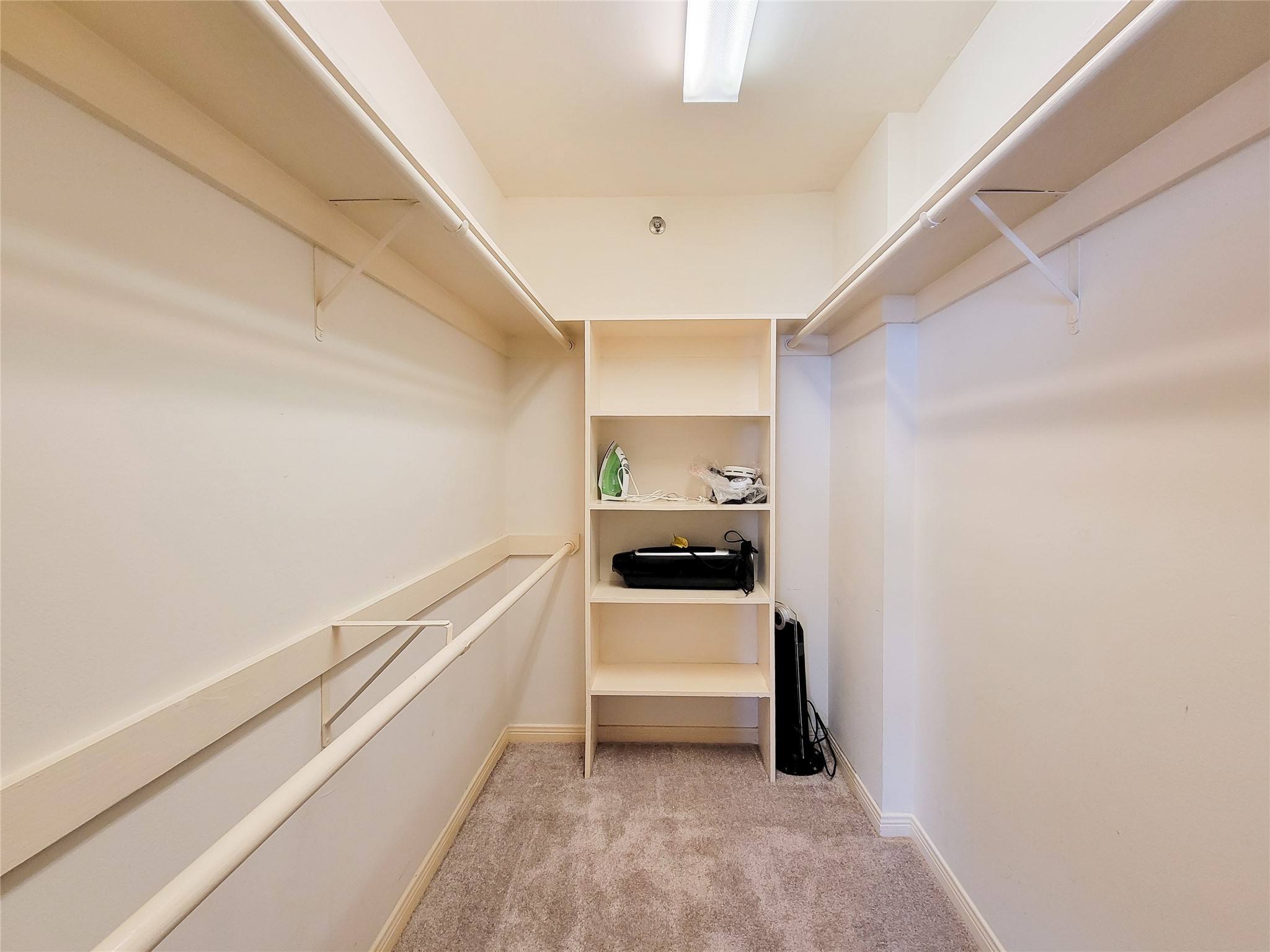 3525 Sage Road, Unit 1605 Houston, TX 77056 - Photo 14 of 33 Oversized walk-in closet with carpet flooring, built-in shelves, and ample hanging space, featuring good lighting.