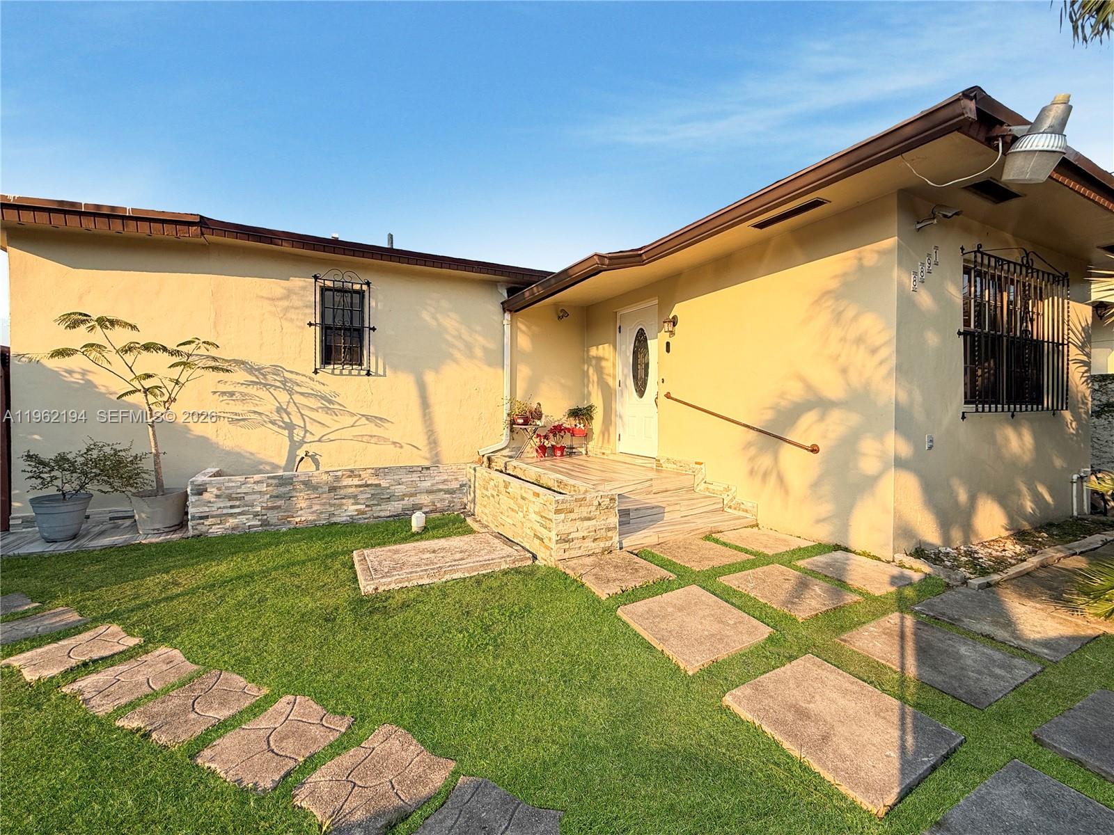 8891 Southwest 28th Street Miami, FL 33165 - Photo 2 of 25 a front view of a house with garden