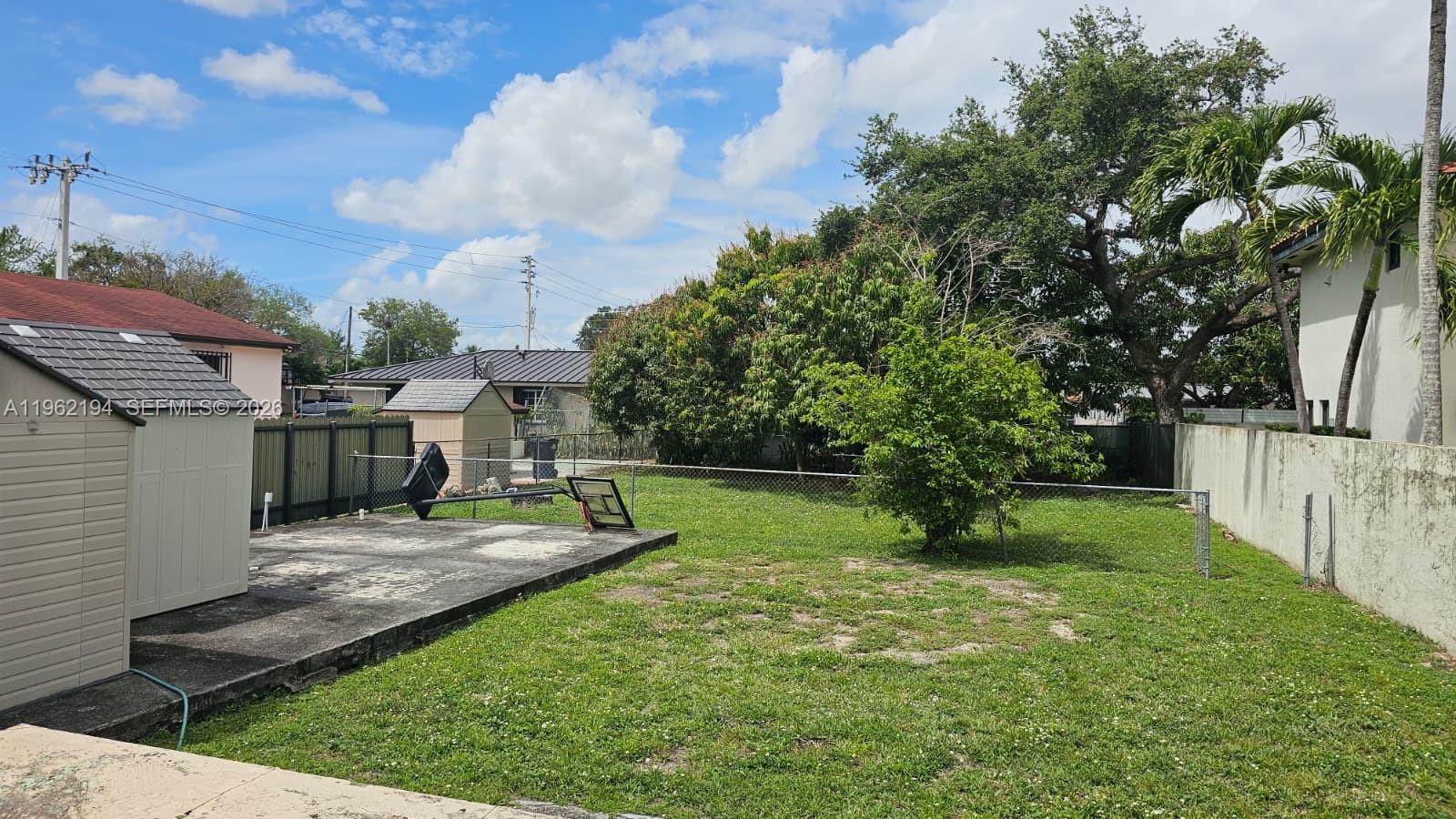 8891 Southwest 28th Street Miami, FL 33165 - Photo 25 of 25 a view of a backyard with couches plants and large trees