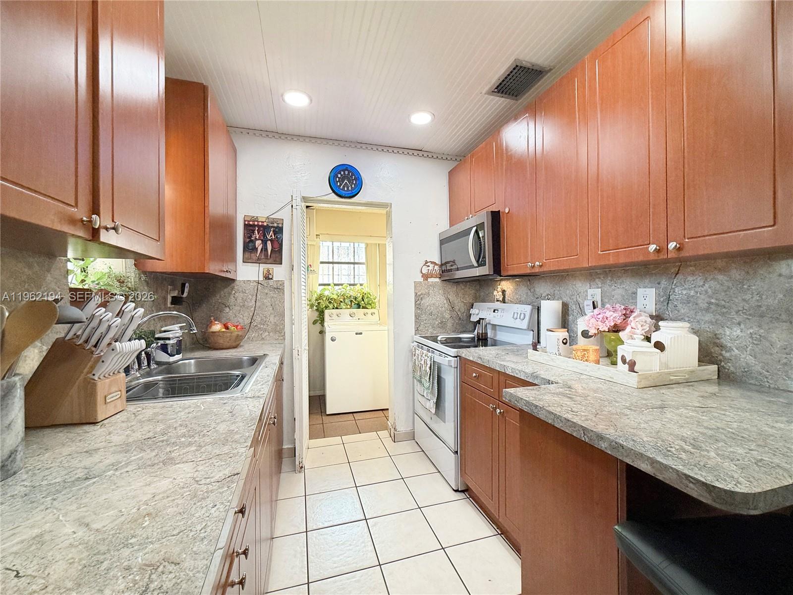 8891 Southwest 28th Street Miami, FL 33165 - Photo 5 of 25 a kitchen with sink cabinets and stove top oven