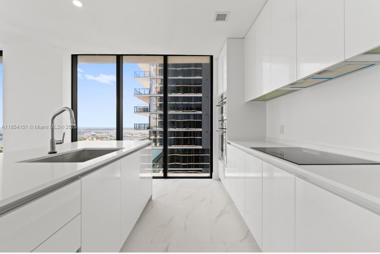 700 Northeast 24th Street, Unit 4907 Miami, FL 33137 - Photo 14 of 47 a kitchen with a sink and cabinets