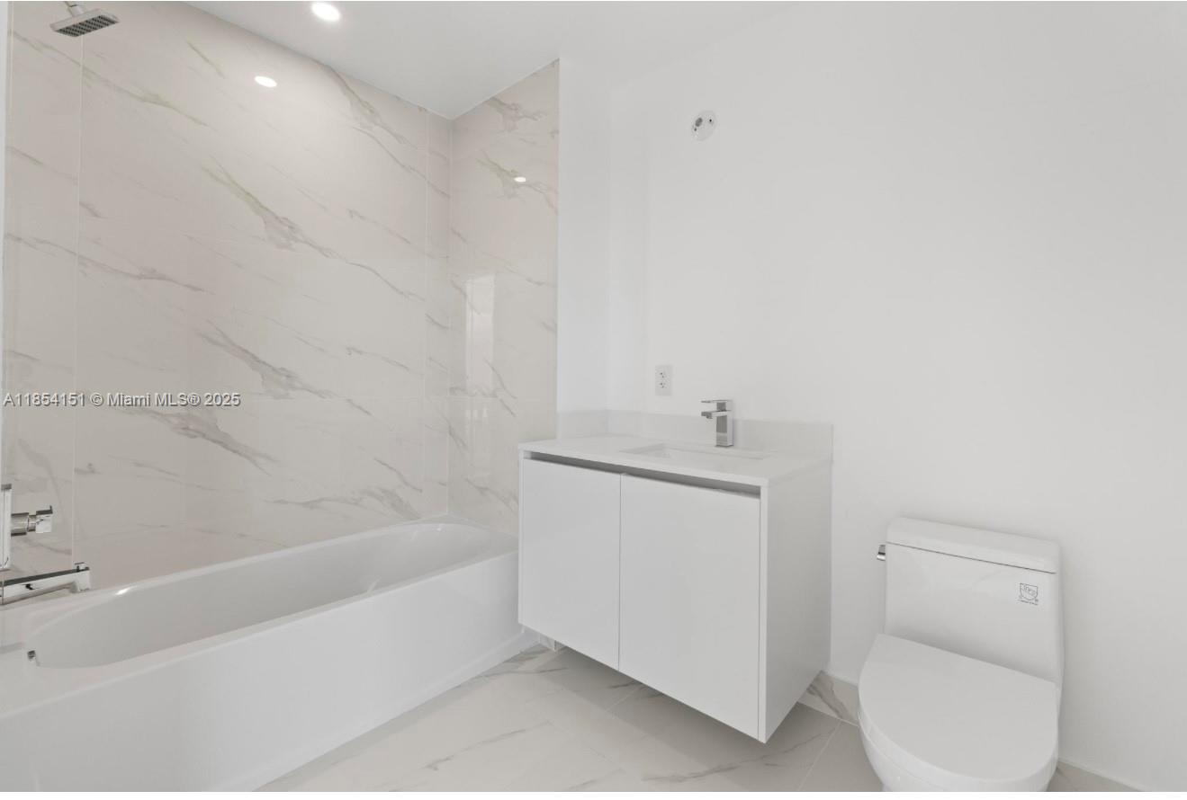 700 Northeast 24th Street, Unit 4907 Miami, FL 33137 - Photo 29 of 47 a bathroom with a bathtub sink and toilet