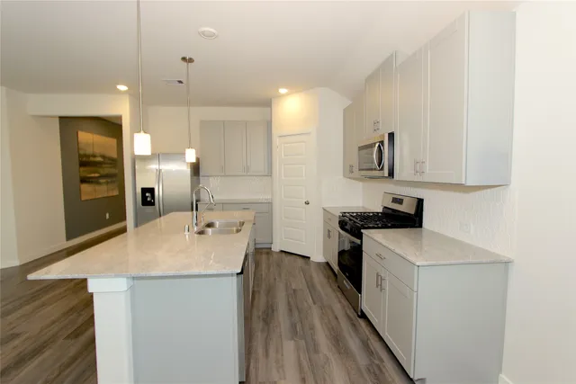 a kitchen with stainless steel appliances a sink stove and refrigerator