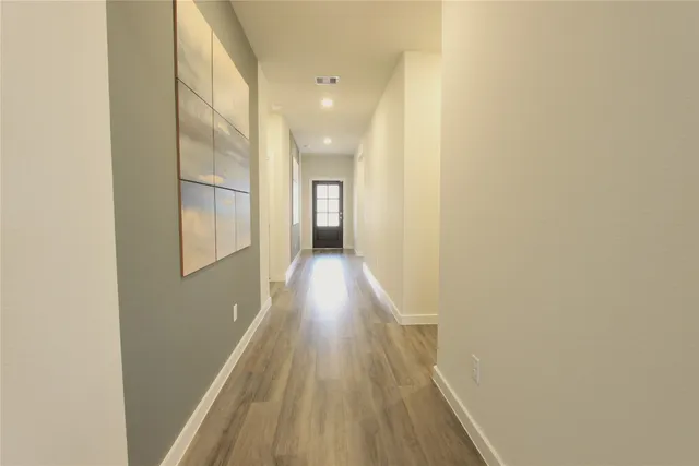 a view of a hallway with wooden floor