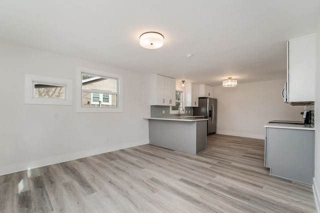 a view of kitchen with wooden floor and electronic appliances