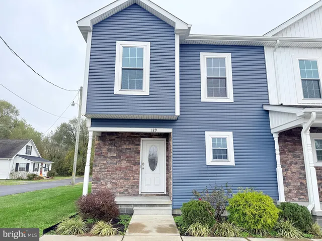 a brick house that has a small yard and large space