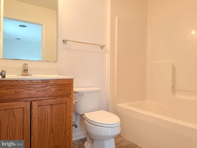 a bathroom with a granite countertop toilet sink and mirror