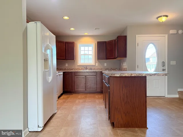a kitchen with stainless steel appliances granite countertop a refrigerator sink and cabinets