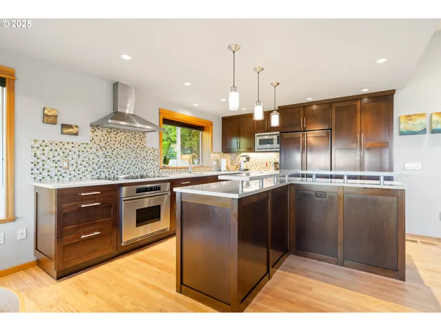 a kitchen with stainless steel appliances granite countertop a stove a sink and a refrigerator