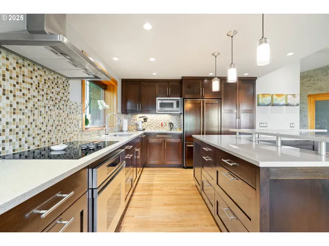 a large kitchen with stainless steel appliances kitchen island granite countertop a sink and cabinets