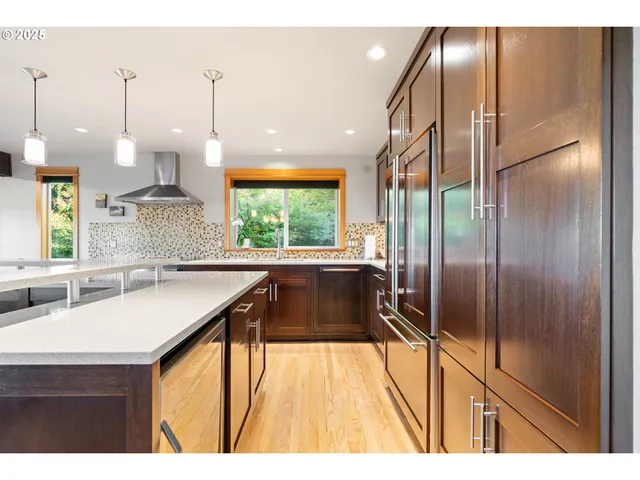 a kitchen with kitchen island granite countertop a sink a counter and stainless steel appliances