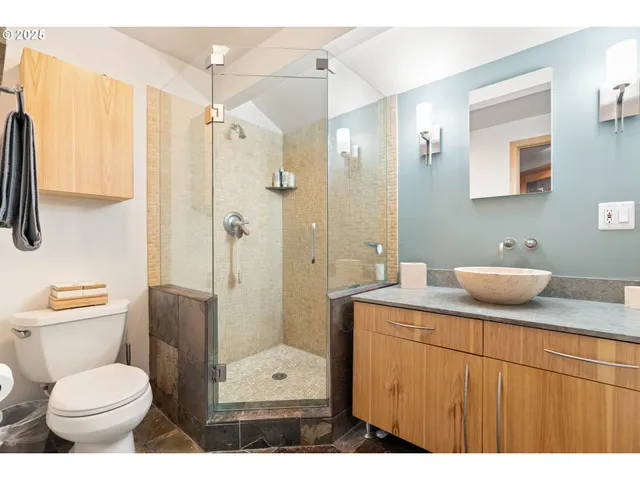 a bathroom with a granite countertop sink toilet and shower