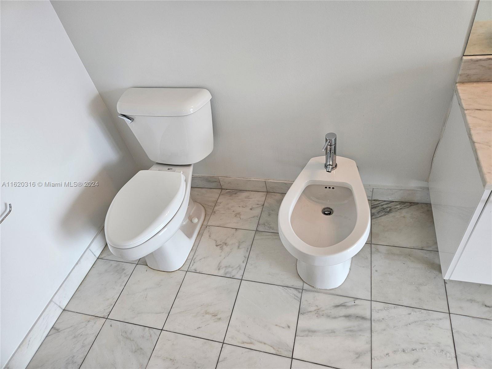 888 Biscayne Boulevard, Unit 2701 Miami, FL 33132 - Photo 12 of 37 a bathroom with a toilet and a washing machine in it