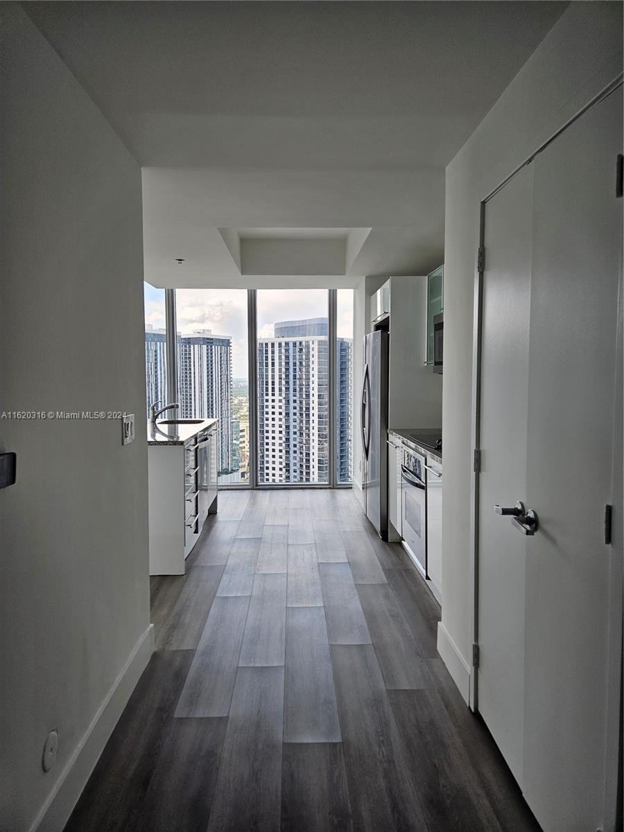 888 Biscayne Boulevard, Unit 2701 Miami, FL 33132 - Photo 14 of 37 a view of a hallway with wooden floor and a bathroom