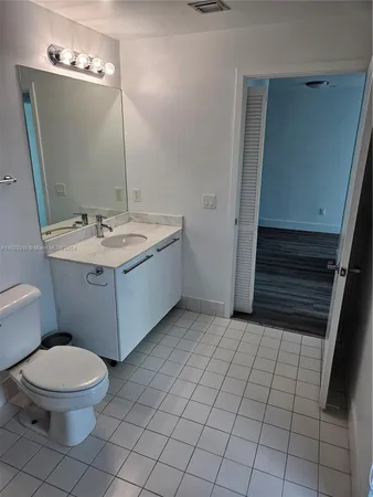a bathroom with a sink a toilet and mirror