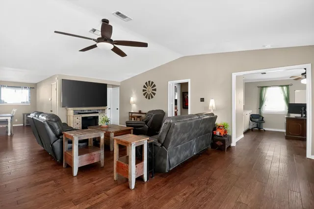 a large kitchen with lots of counter space a sink appliances and living room view