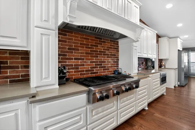a view of kitchen with stove and cabinets