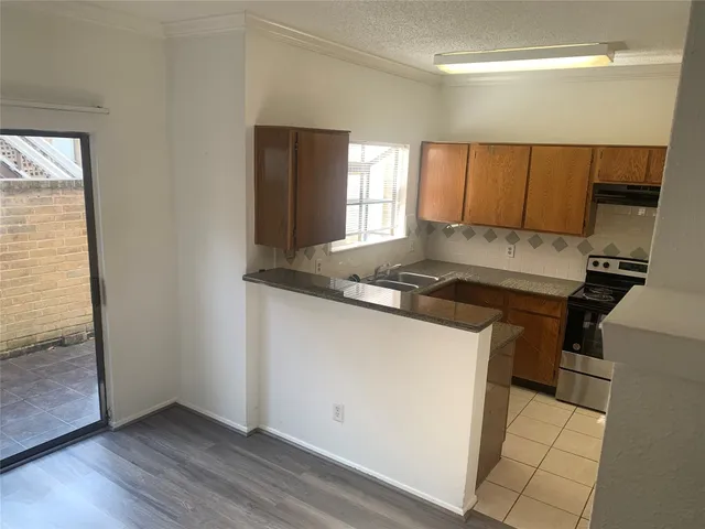 a kitchen with granite countertop a sink and a stove top oven