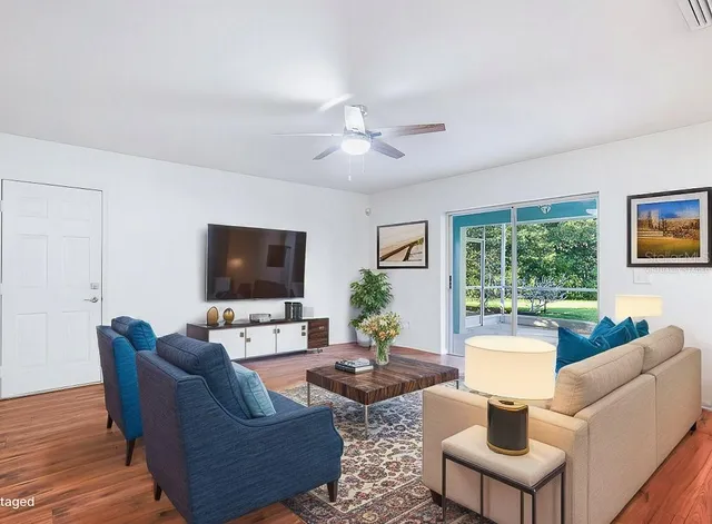 a view of empty room with wooden floor and fan