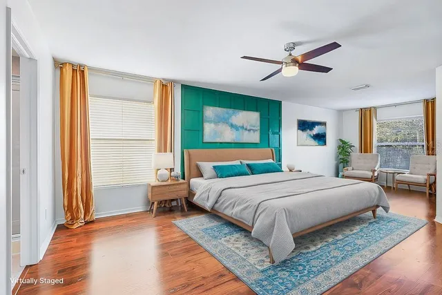 a view of empty room with wooden floor and fan