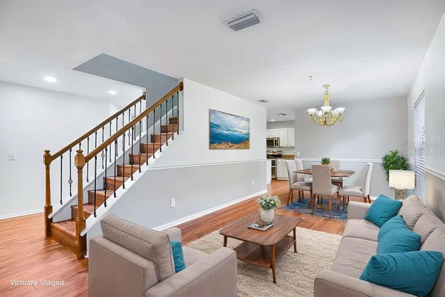 a view of an empty room with wooden floor and a chandelier
