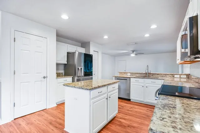 a kitchen with stainless steel appliances granite countertop a stove and a sink