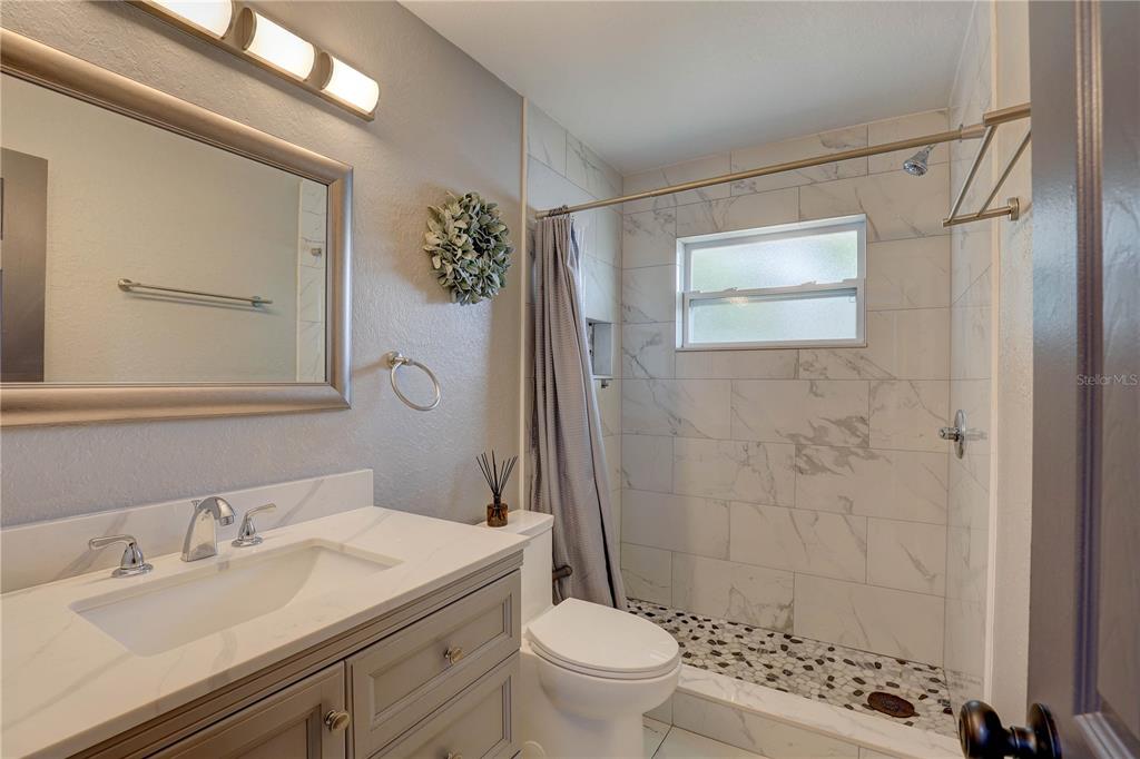 8201 Ridge Road Seminole, FL 33772 - Photo 11 of 36 a bathroom with a sink a toilet and shower