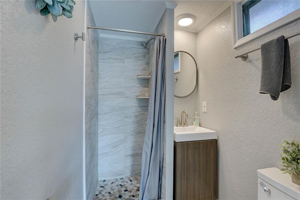 8201 Ridge Road Seminole, FL 33772 - Photo 21 of 36 a bathroom with a shower sink and mirror