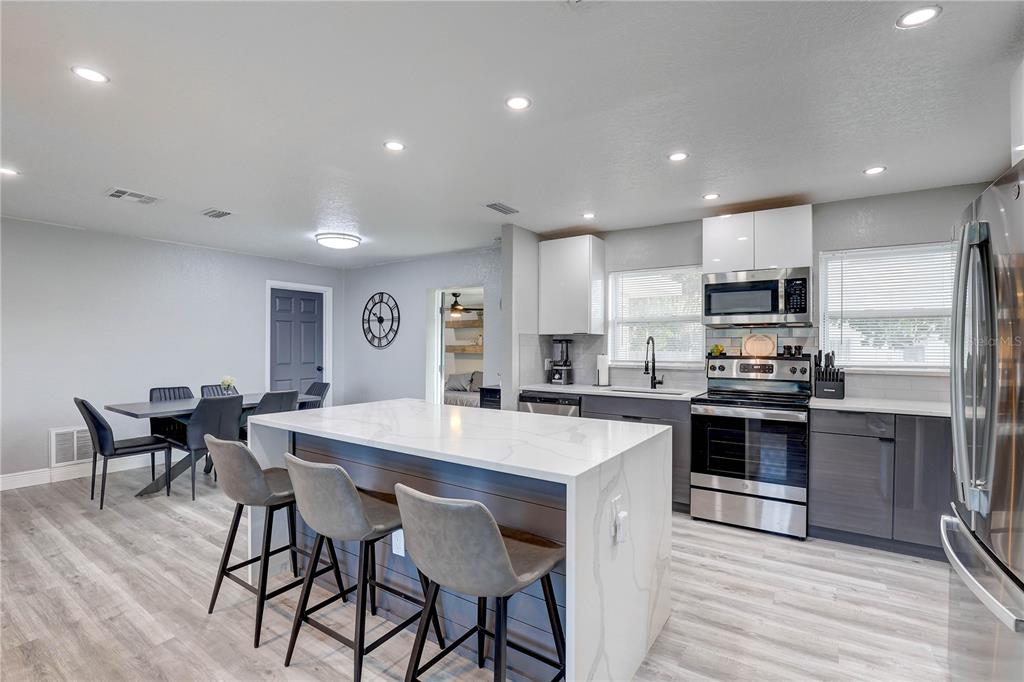 8201 Ridge Road Seminole, FL 33772 - Photo 6 of 36 a large kitchen with kitchen island wooden cabinets and stainless steel appliances