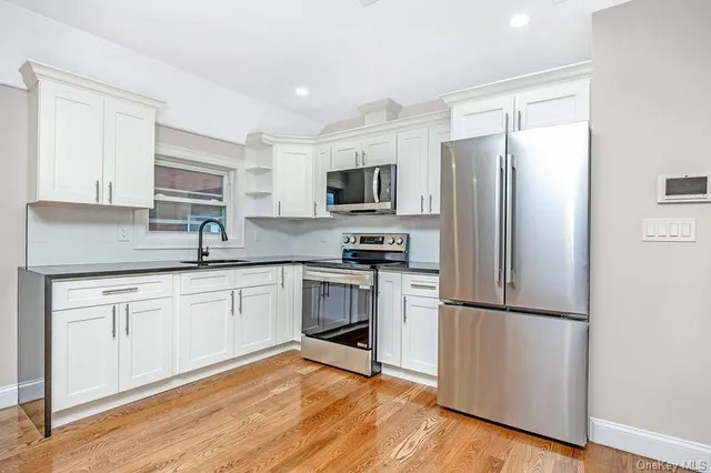 a kitchen with appliances a sink and cabinets